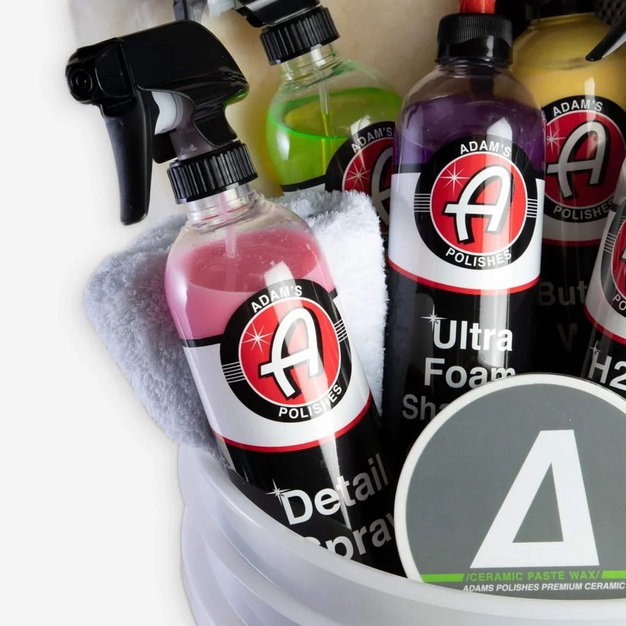 Polishing compounds and detail sprays staged in a wash bucket