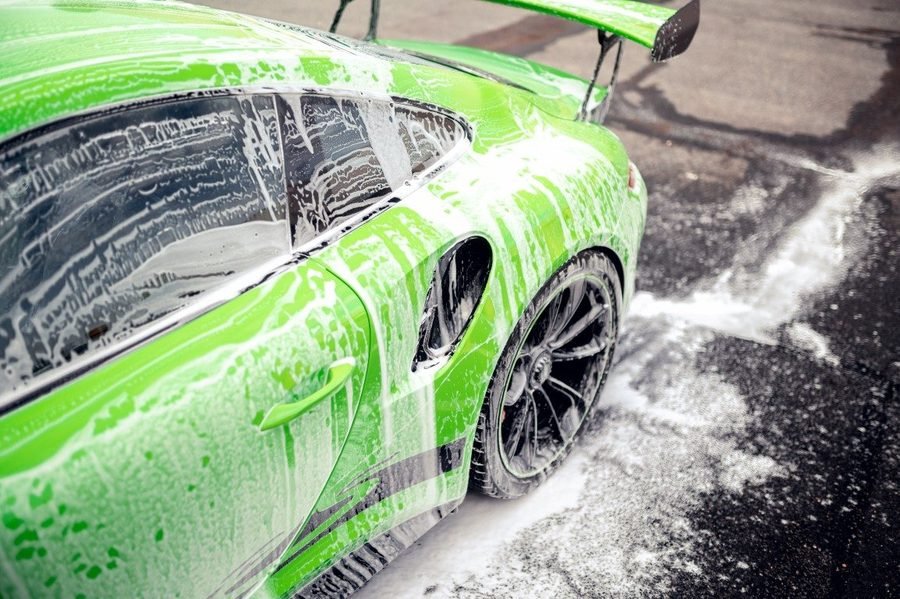 Sports car covered in wash foam during an exterior hand wash and wax service